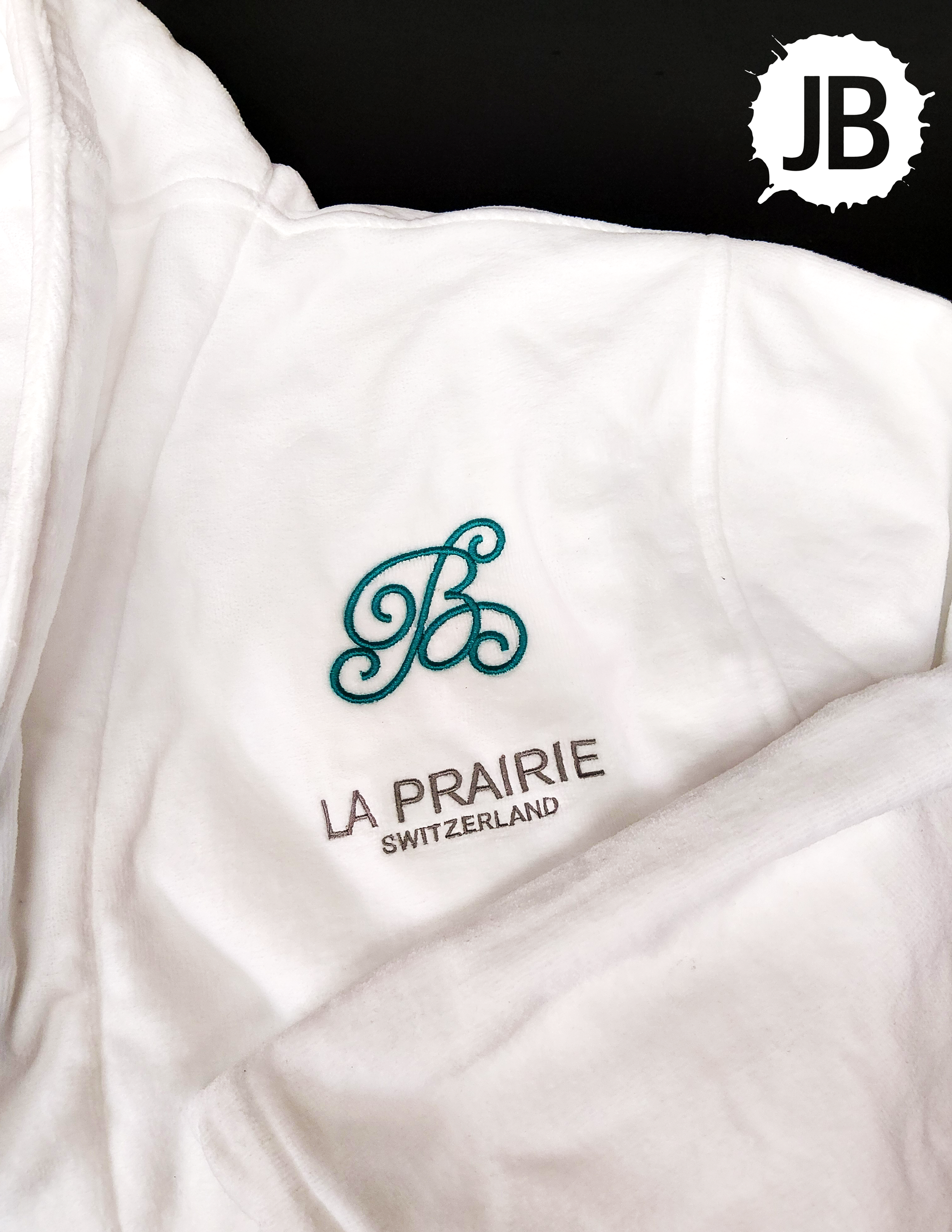 White terry cloth robe embroidered with the Bloomindales Hotel logo on the left chest